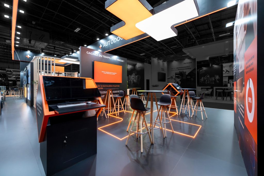 Photo de la surface d'échange commerciaux du stand sur-mesure réalisé par R2 Stand pour Autodoc sur le salon Equipauto avec la reprise du logo au sol par des leds aux couleurs de la marque