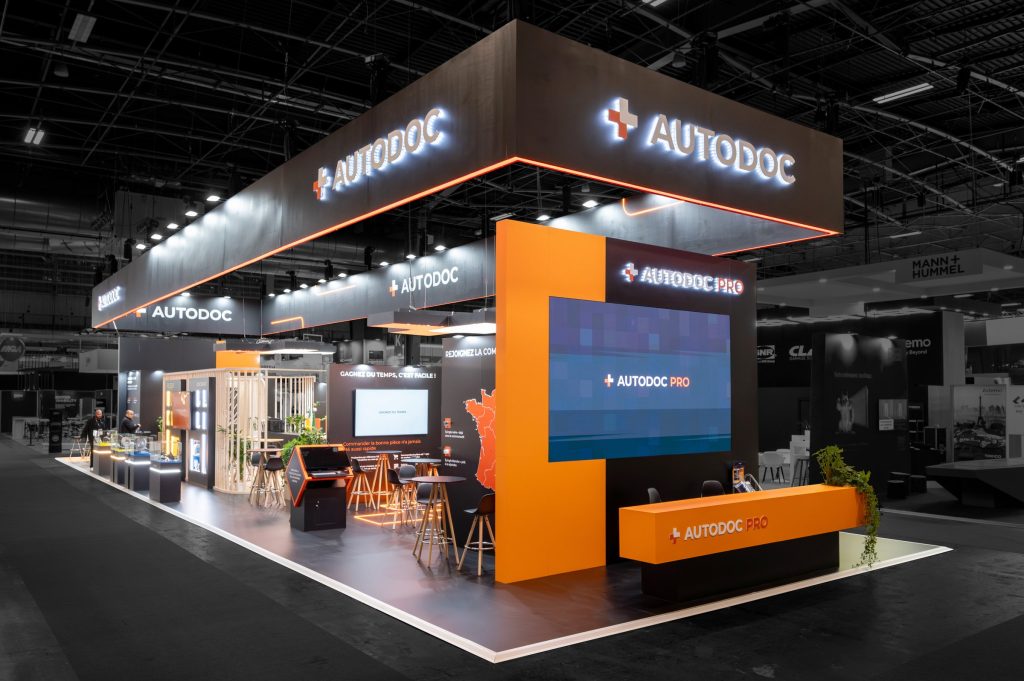 Photo de l'angle d'attaque du stand sur-mesure réalisé par R2 Stand pour Autodoc sur le salon Equipauto avec le comptoir d'acceuil et les différents espaces d'aménagement