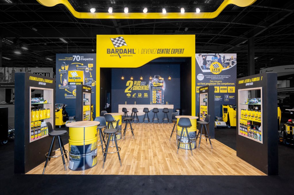 Vue de l'intérieur du stand sur-mesure réalisé par R2 Stand pour Bardahl sur le salon Equipauto avec son espace réceptif composé d'un bar et de tables hautes