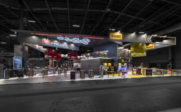 Vue de côté du stand sur-mesure Facom réalisé par R2 Stand sur le salon Equipauto mettant en avant les deux marques du groupe SBDInc : Facom et DeWalt