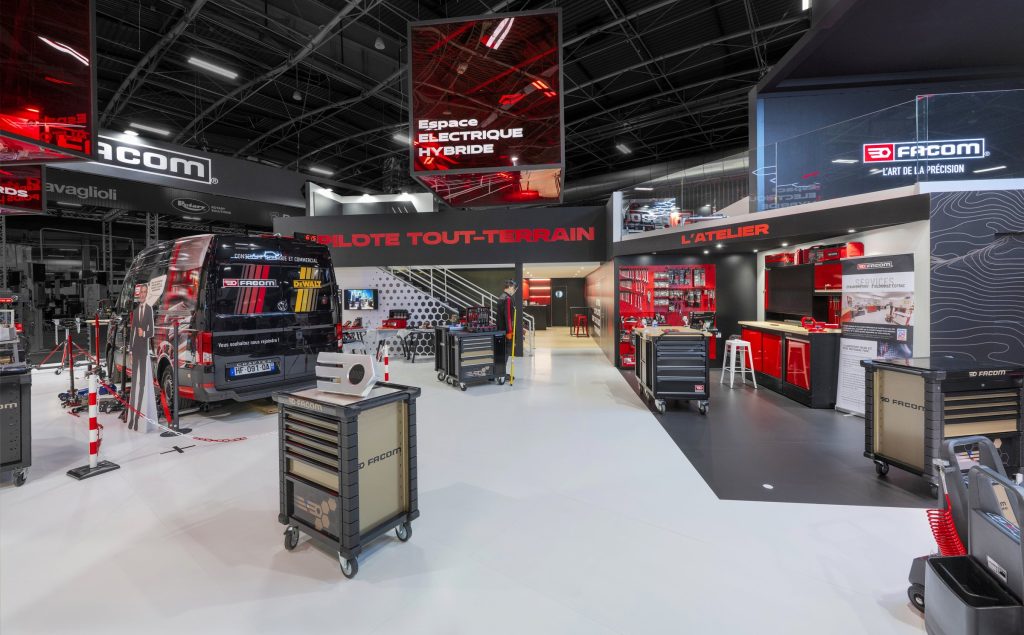 Photo de détail de l'intérieur du stand sur-mesure Facom réalisé par R2 Stand sur le salon avec détail du bar et de l'escalier d'accès à la mezzanine ainsi que les produits et camionnette à l'image de la marque