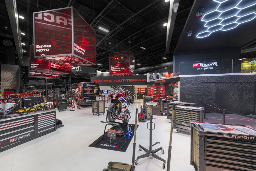 Photo de l'intérieur du stand sur-mesure Facom réalisé par R2 Stand sur le salon Equipauto avec de nombreux produits en présentation et une vue sur la mezzanine du stand et son espace business