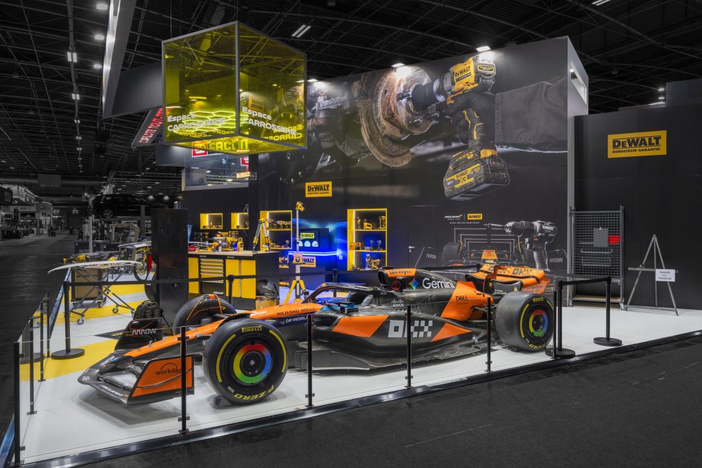 Photo de l'espace DeWalt du stand sur-mesure Facom réalisé par R2 Stand sur le salon Equipauto avec une formule 1 en premier plan