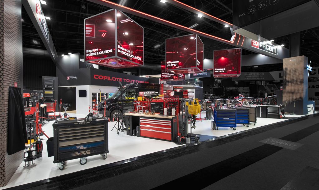 Photo d'ensemble du stand sur-mesure Facom réalisé par R2 Stand sur le salon Equipauto avec les produits présenté et les imposants cubes rouges qui présentent les espaces