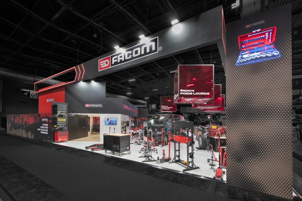 Photo d'ensemble du stand sur-mesure Facom réalisé par R2 Stand sur le salon Equipauto avec les produits présenté et l'espace bar en arrière plan
