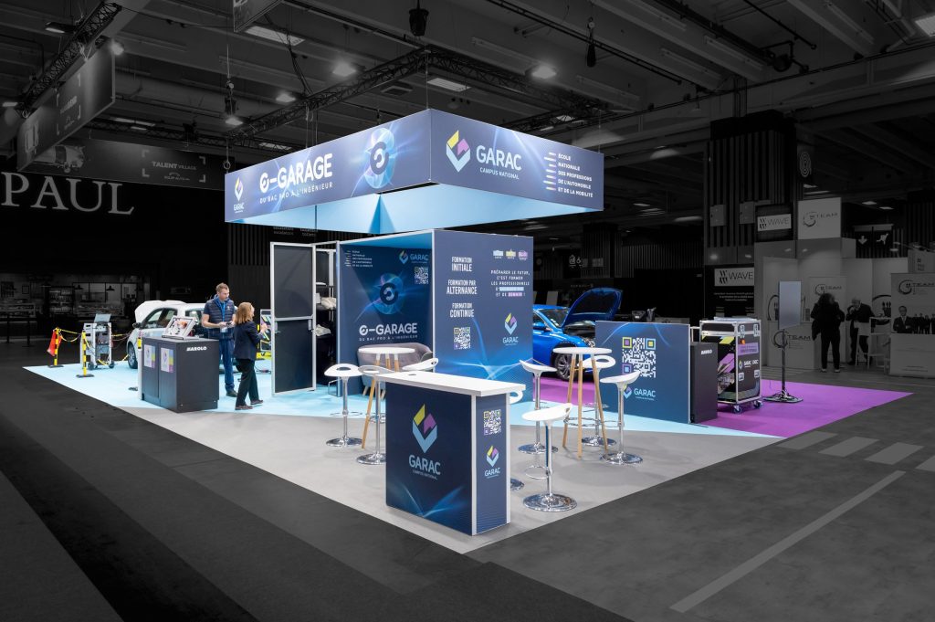 Vue d'ensemble du stand modulaire réalisé par R2 Stand pour son client Garac sur le salon Equipauto avec ses comptoirs d'accueil