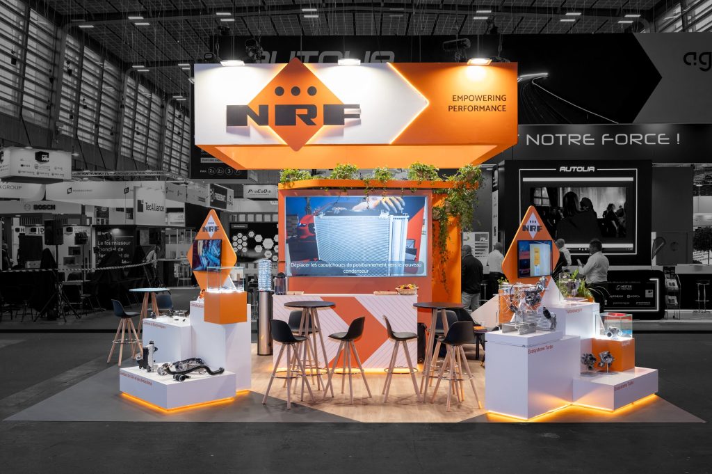 Vue de face du stand sur-mesure aux couleurs de la marque hollandaise réalisé par R2 Stand pour NRF sur le salon Equipauto avec podium produits, bar et écran géant
