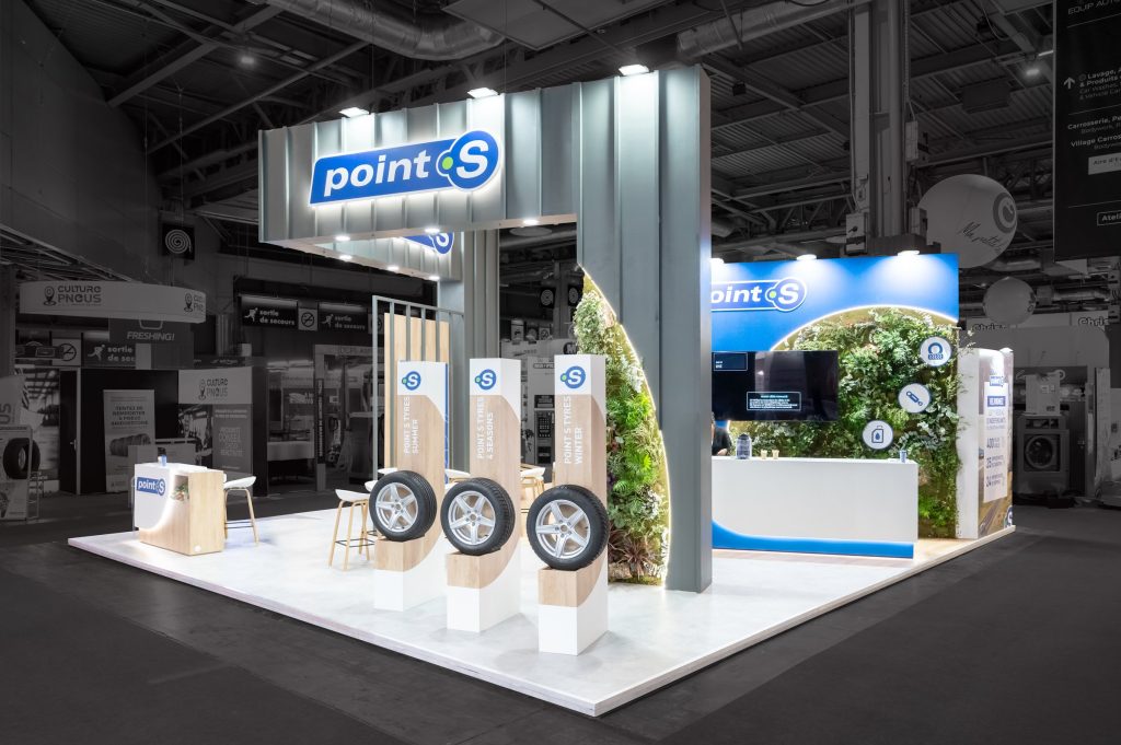 Photo d'angle du stand sur-mesure réalisé par l'agence R2 Stand Lyon pour son client Point S mettant en avant les différents produits distribués par l'enseigne