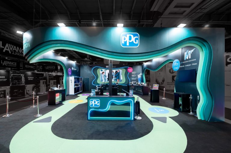 Front view of the visitor area of the custom-built stand created by R2 Stand and Event for its client PPG at the Equipauto trade show, highlighting the colorful and vibrant design of the stand as well as the various elements used to present the solutions on offer.2
