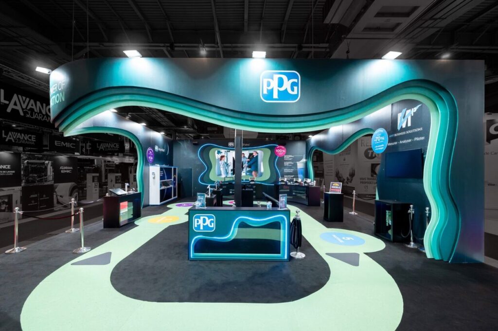 Vue de face de la partie parcours visiteurs du stand sur-mesure réalisé par R2 Stand et Event pour son client PPG sur le salon Equipauto mettant en avant le côté coloré et acidulé du stand ainsi que les différents éléments de présentation des solutions proposées