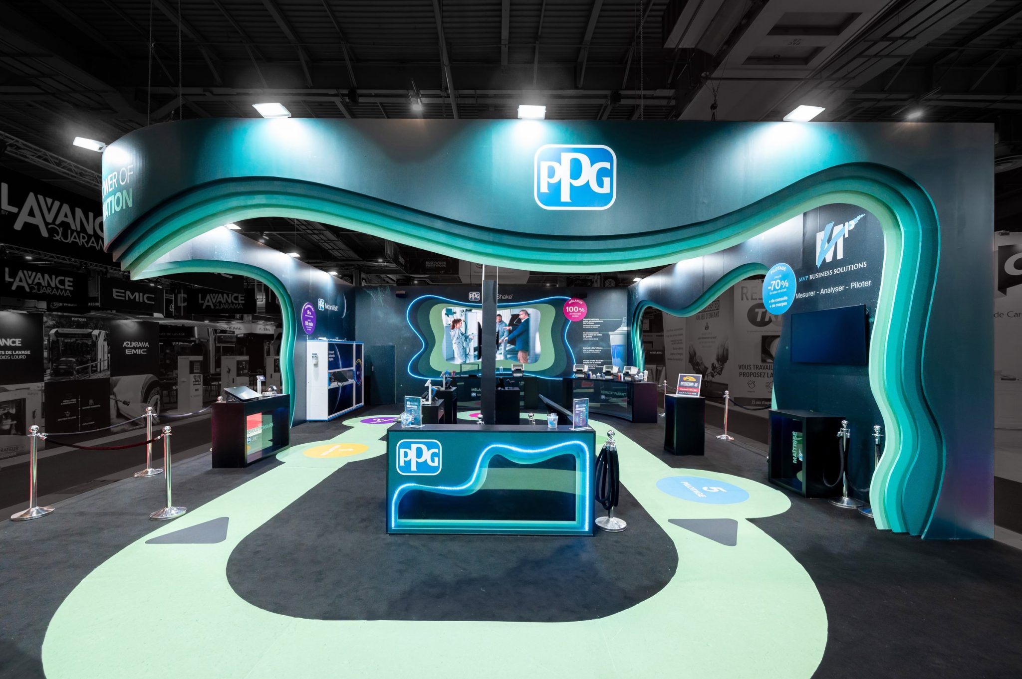 Front view of the visitor area of the custom-built stand created by R2 Stand and Event for its client PPG at the Equipauto trade show, highlighting the colorful and vibrant design of the stand as well as the various elements used to present the solutions on offer.2