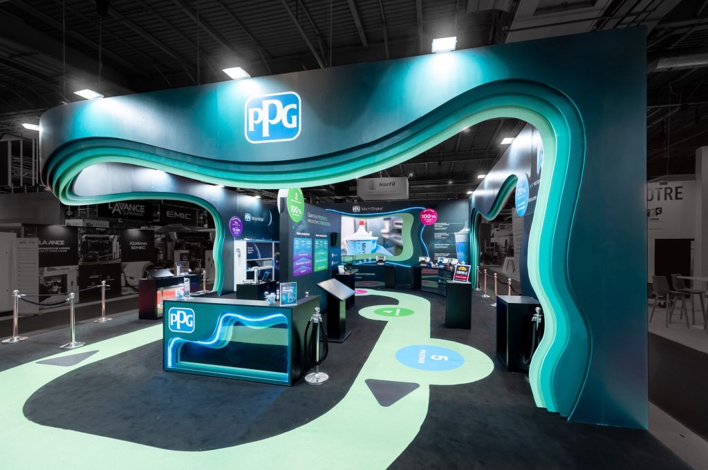 Vue de côté de la partie parcours visiteurs du stand sur-mesure réalisé par R2 Stand et Event pour son client PPG sur le salon Equipauto mettant en avant le côté coloré et acidulé du stand ainsi que les différents éléments de présentation des solutions proposées