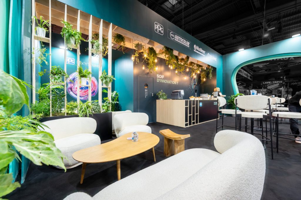 Vue de la partie salon du stand réalisé par R2 Stand et Event pour son client PPG sur le salon Equipauto ainsi que le bar de la partie réception et l'accès aux salles de réunions
