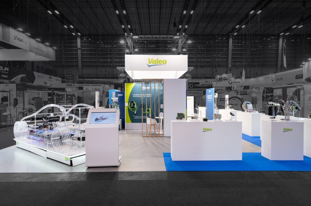 Photo du côté du stand modulaire Valéo réalisé par R2 Stand sur Equipauto, avec vue sur présentation produit, borne tactile et voiture de démonstration